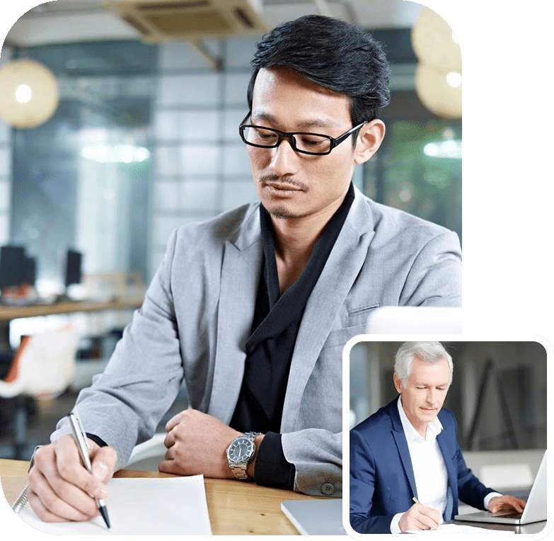 A man sitting at a table writing on paper.