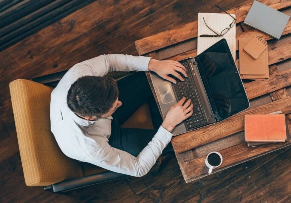 A man sitting at a table with his laptop.